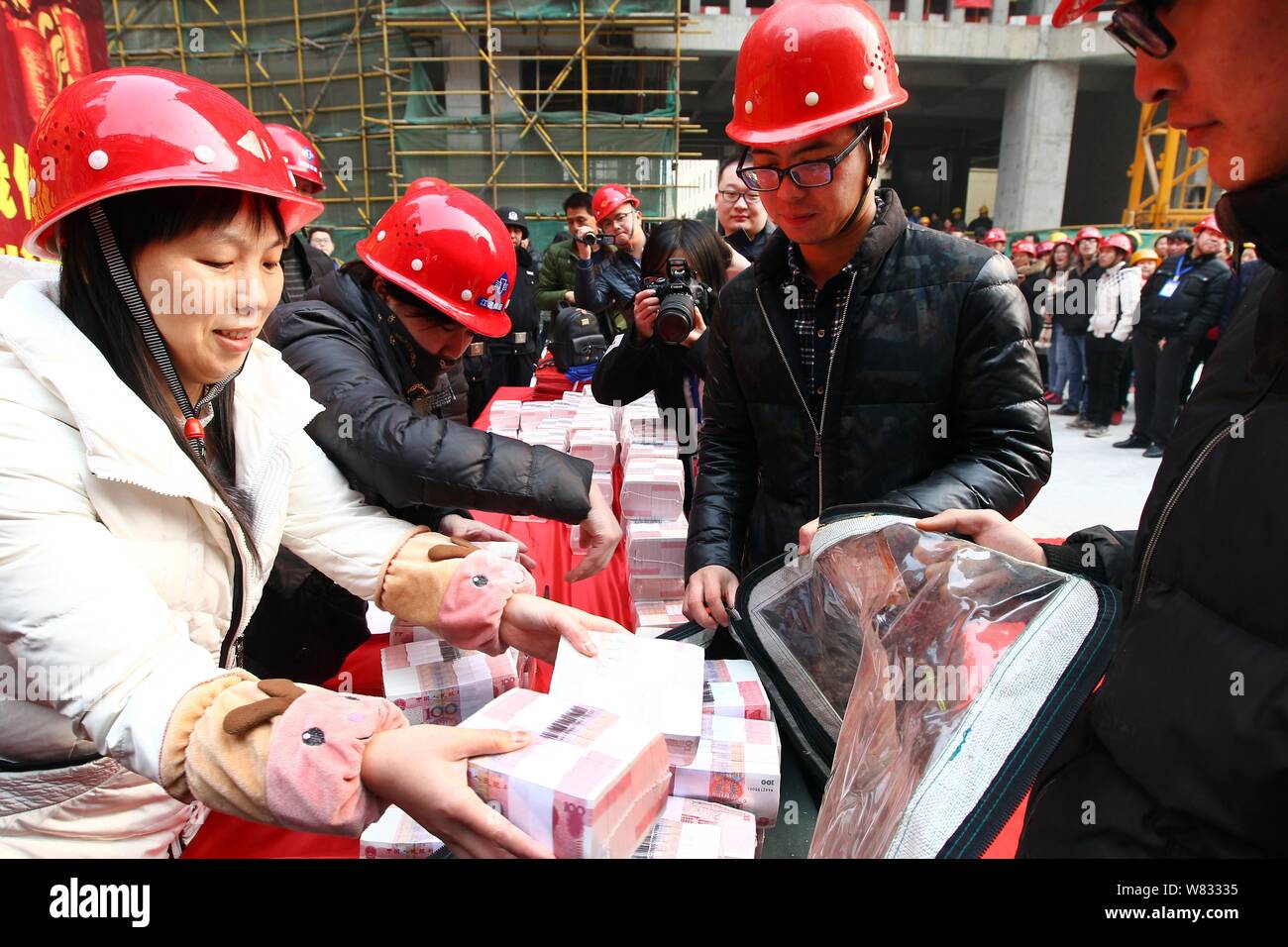 Chinese migrant workers get bundles of 100-yuan RMB (Renminbi ...