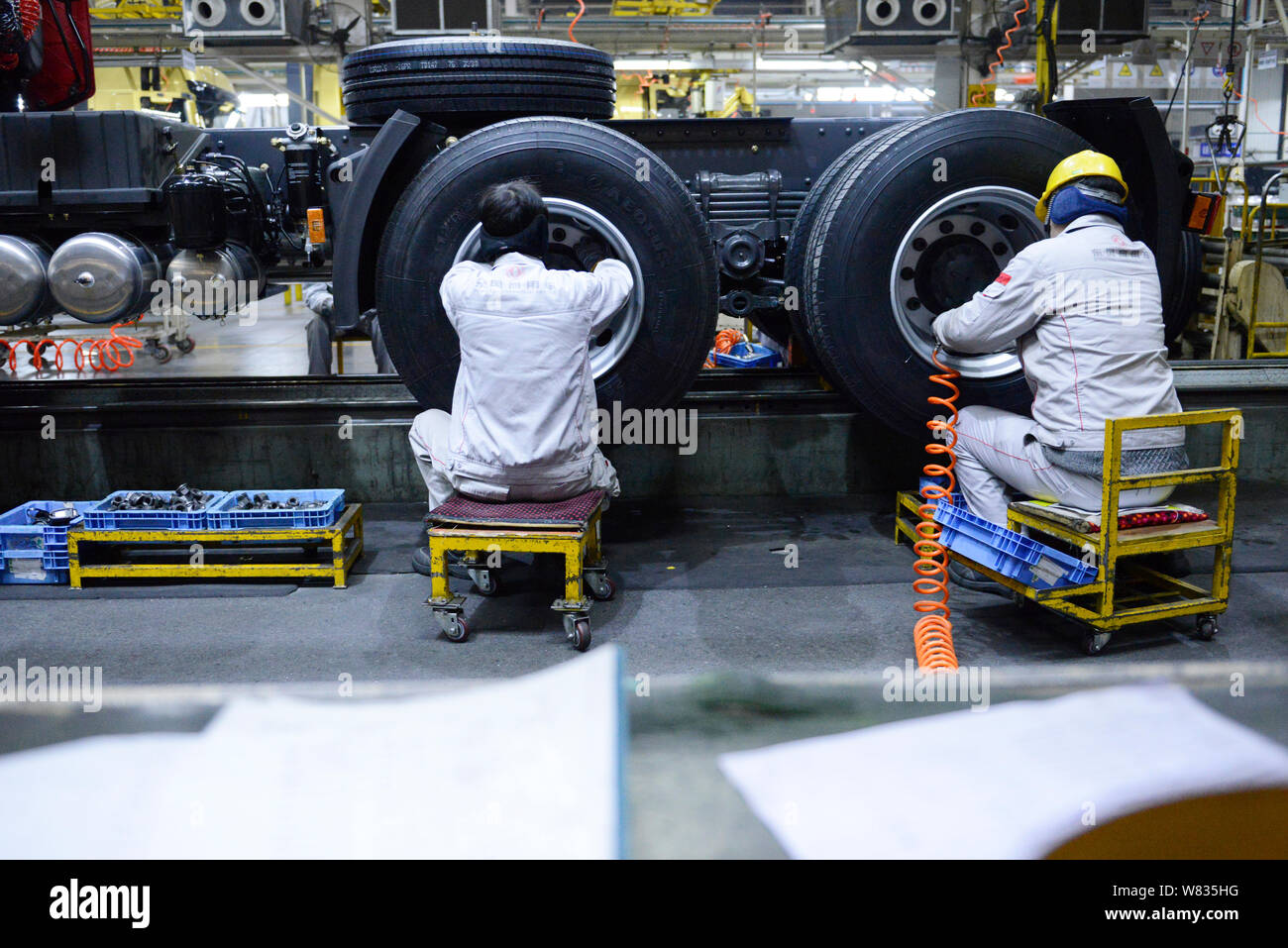 --FILE--Chinese workers assemble a truck on the assembly line at an ...