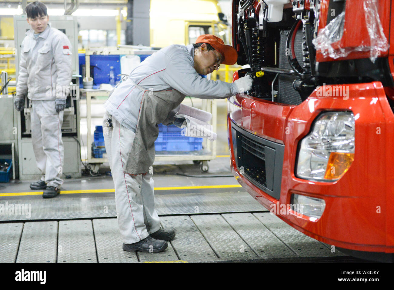 --FILE--A Chinese worker assembles a truck on the assembly line at an ...