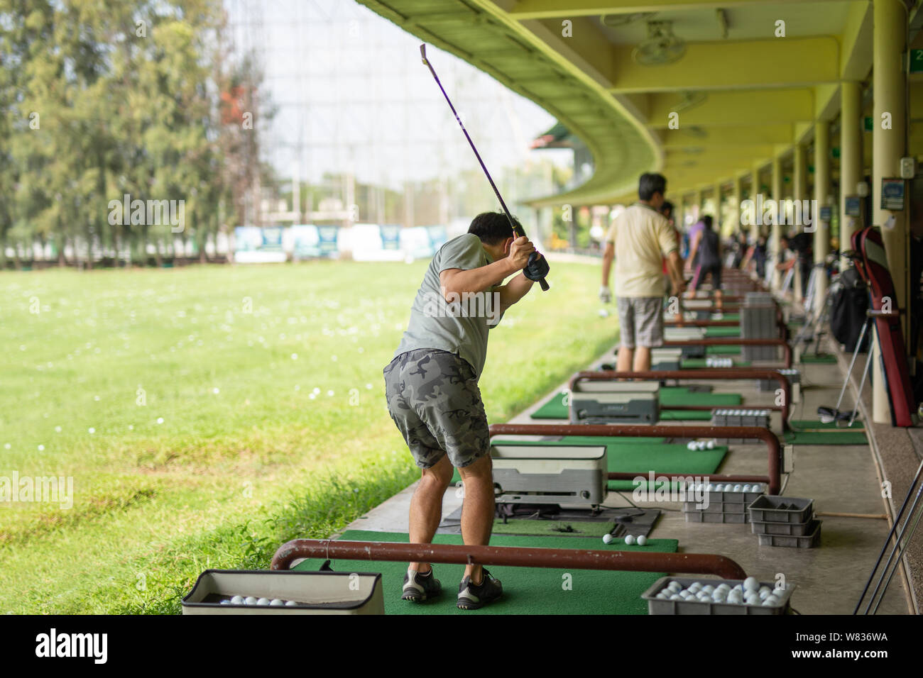 Man practicing his golf swing at golf driving range Stock Photo Alamy