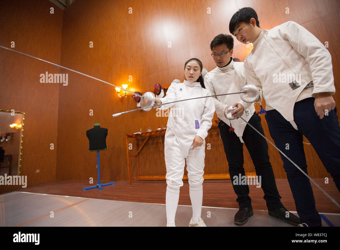 Chinese fencing trainer Mou Jiahui, left, instructs fencing skills to learners at her training center in Jilin city, northeast China's Jilin province, Stock Photo