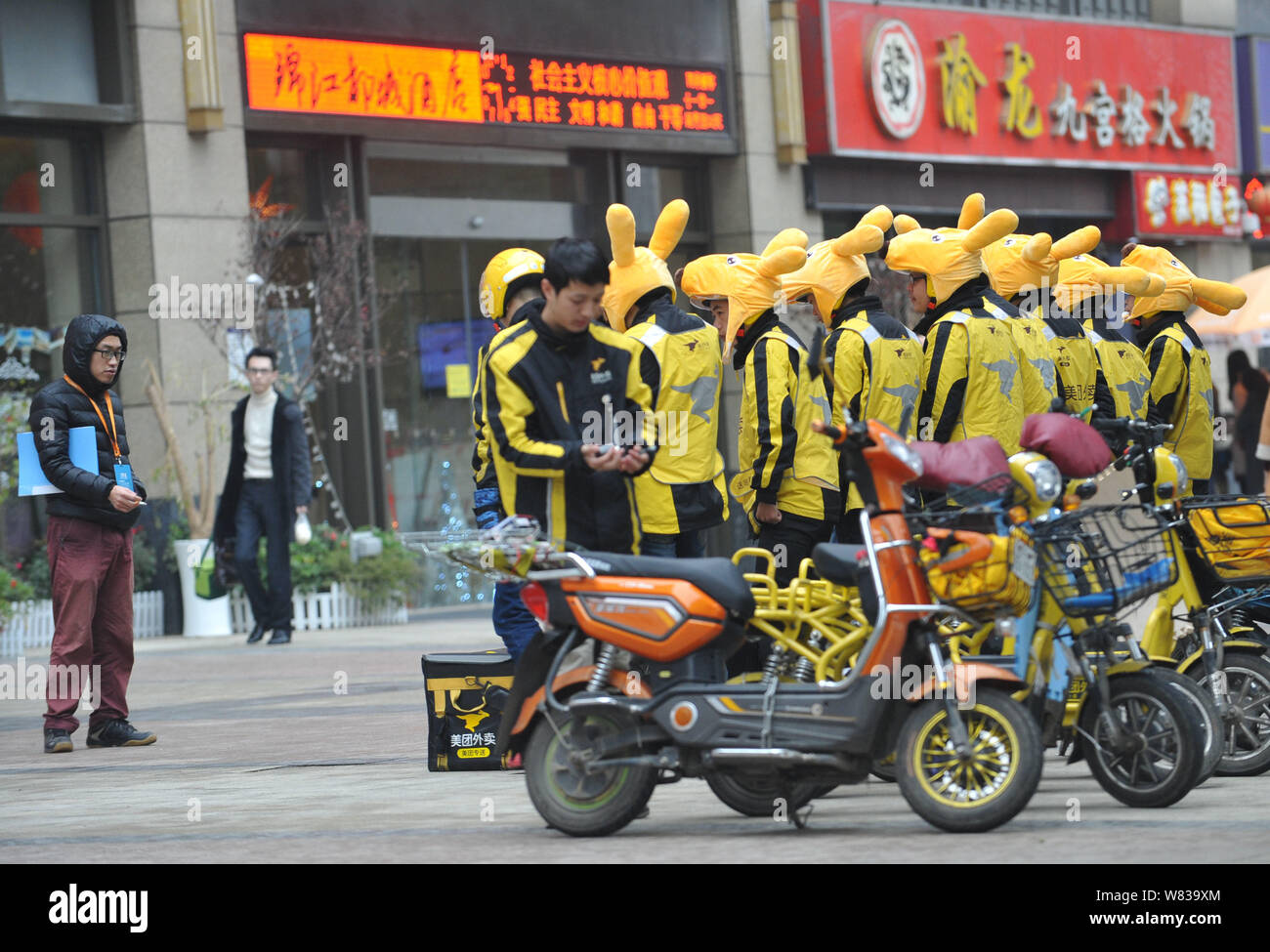 Couriers of Chinese online food delivery company Meituan wearing