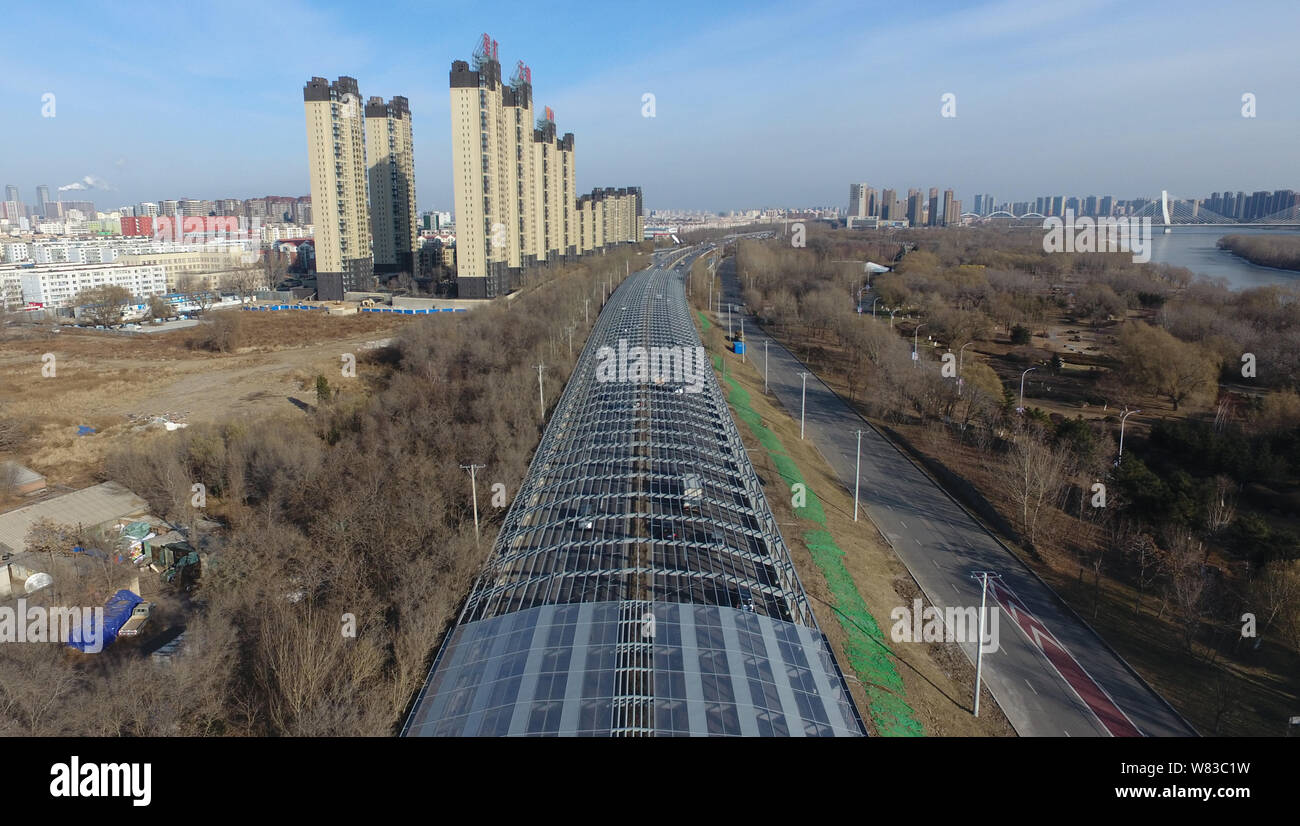 Aerial view of an elevated road fully covered by noise-reduction shelters in Shenyang city, northeast China's Liaoning province, 5 December 2016.    A Stock Photo