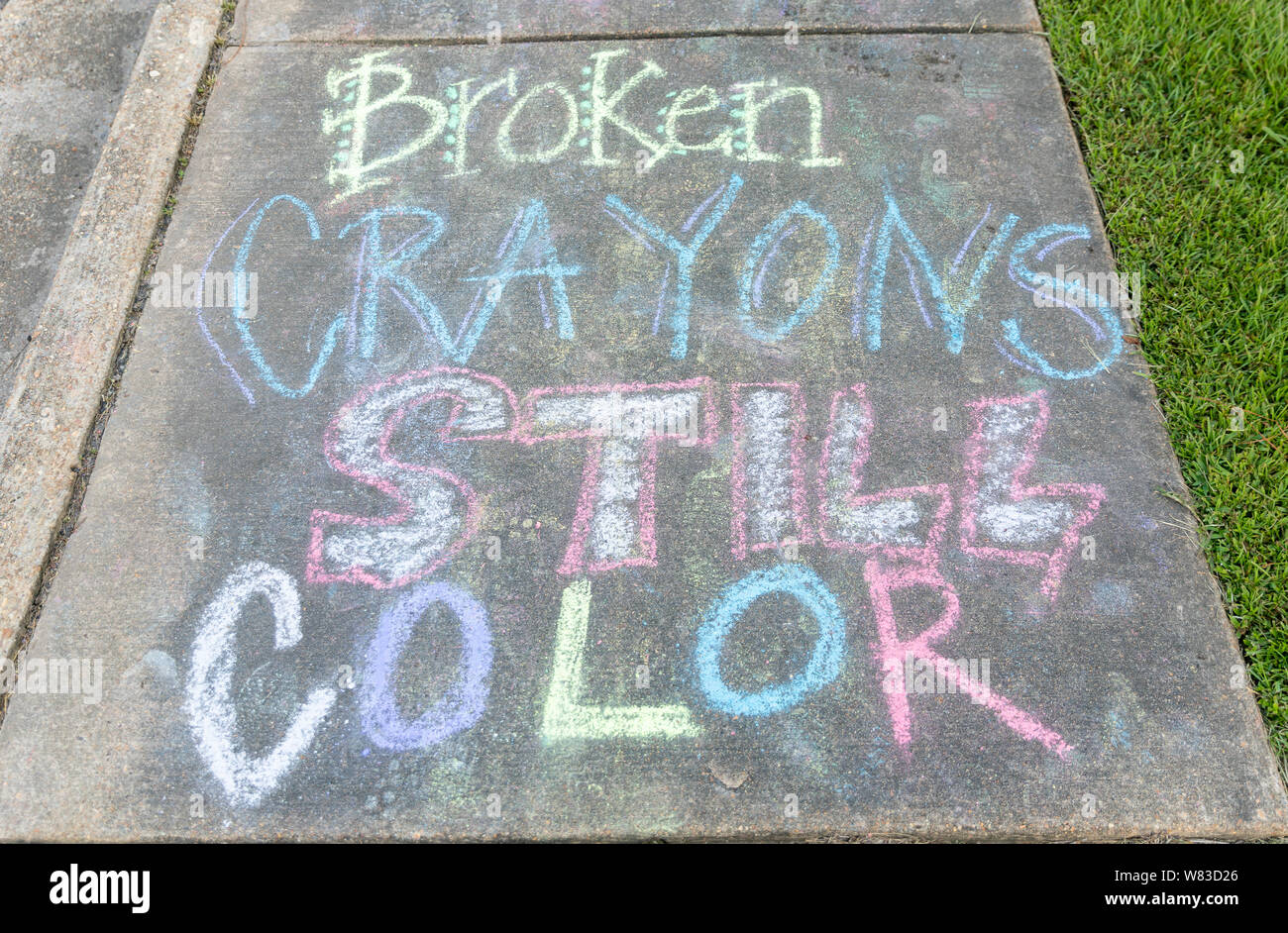 the words "Broken Crayons still color" written with sidewalk chalk on