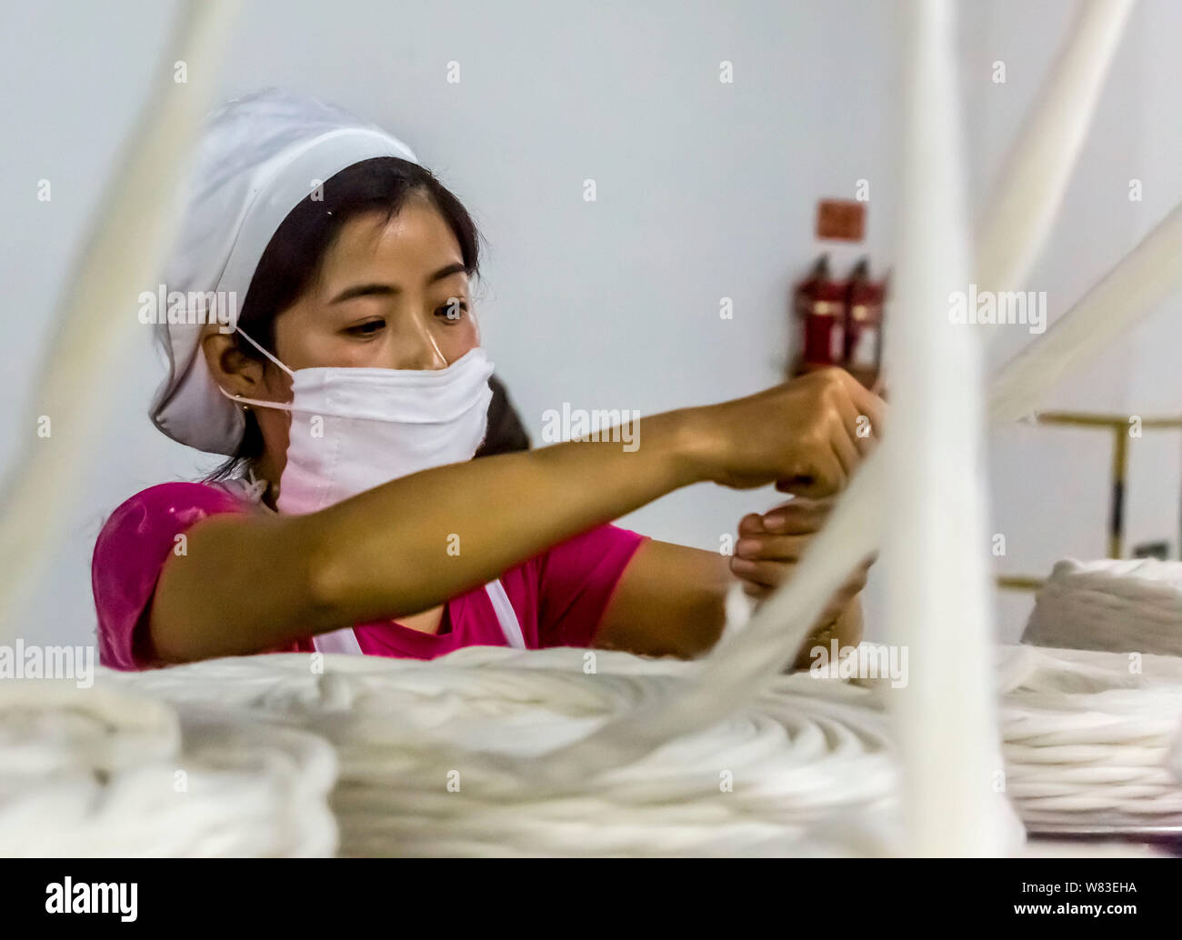 --FILE--A female Chinese worker handles production of yarn at a textile ...