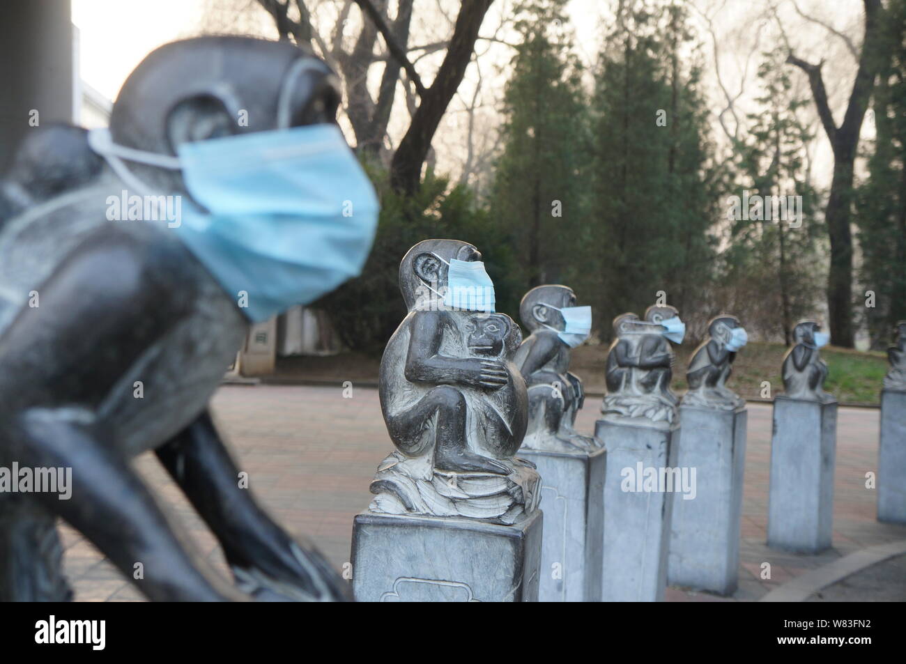 Stone monkey sculptures are seen wearing face masks in heavy smog at
