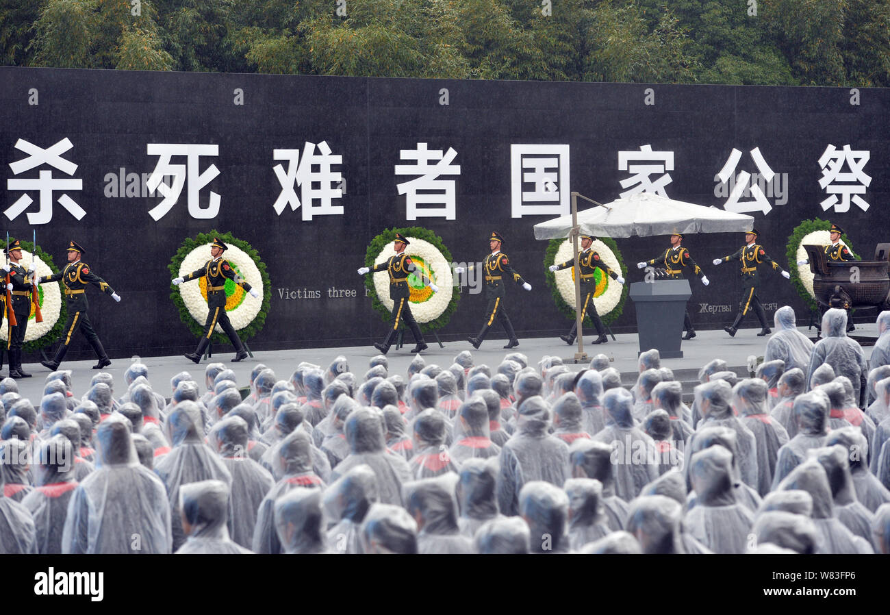 Chinese People's Liberation Army officers march as local residents stand in silent tribute at the Memorial Hall of the Victims in Nanjing Massacre by Stock Photo