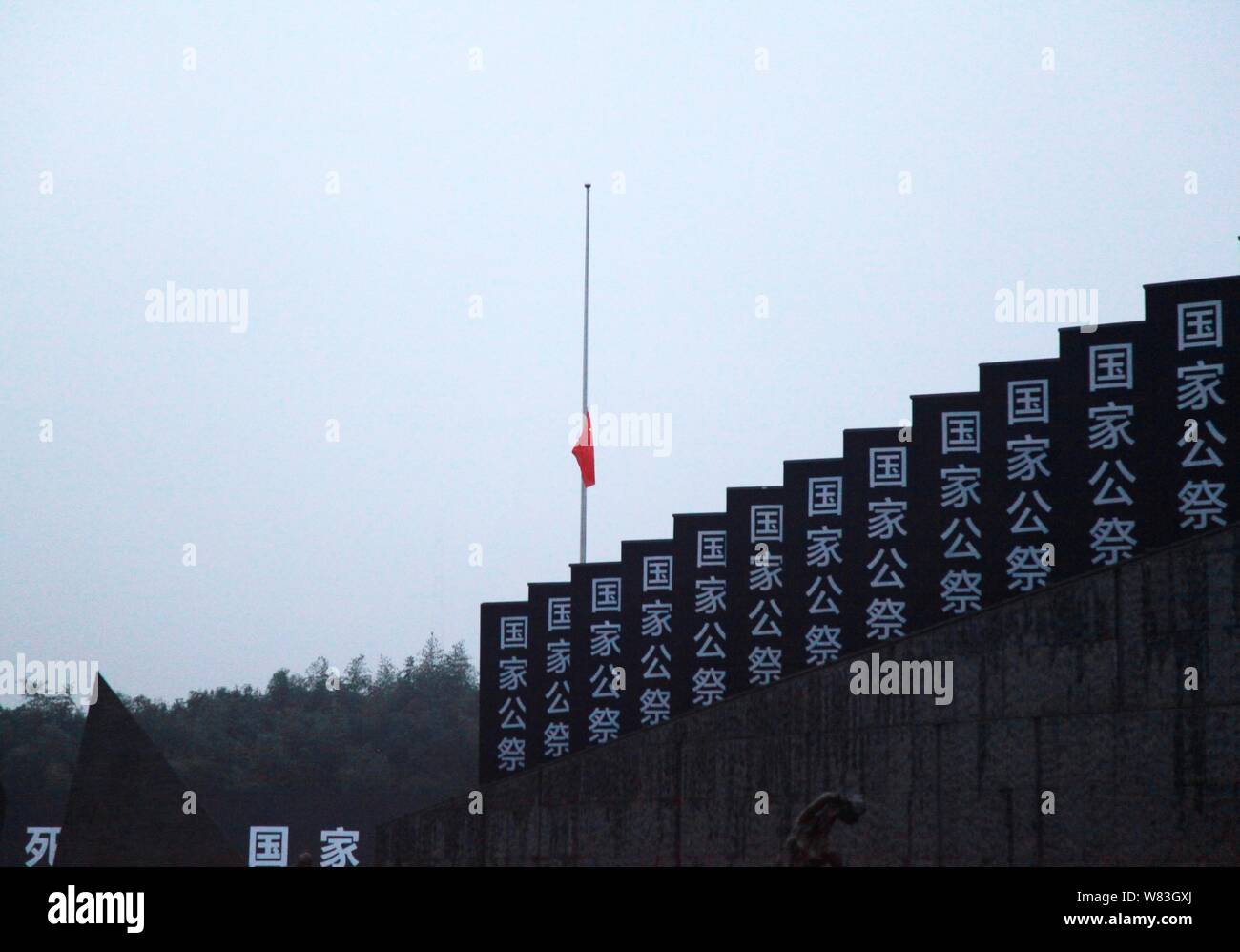 Chinese national flag flies at half-mast to mourn for victims at the Memorial Hall of the Victims in Nanjing Massacre by Japanese Invaders on China's Stock Photo