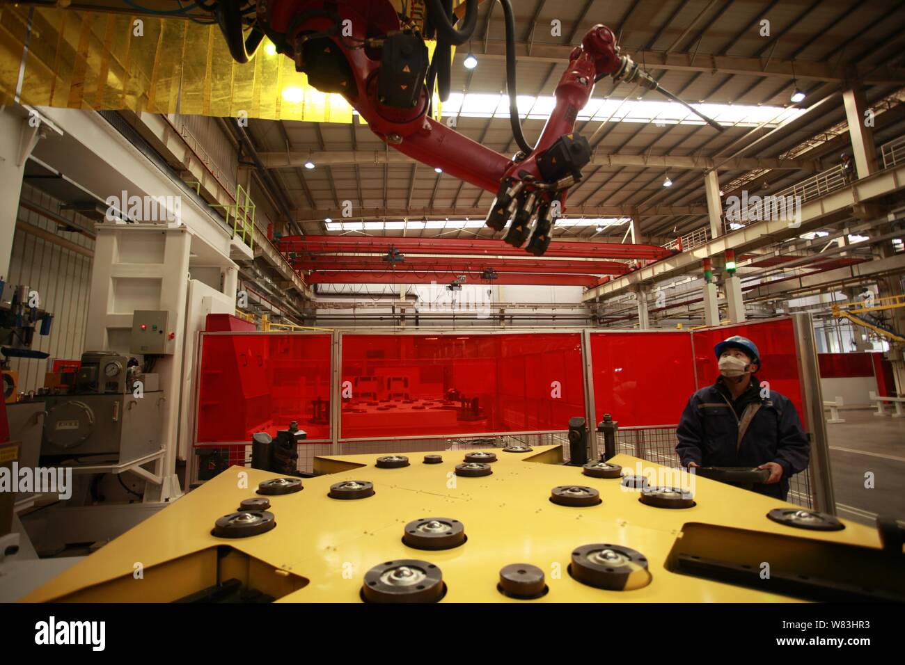 --FILE--A Chinese worker checks a welding robot arm at a factory in ...