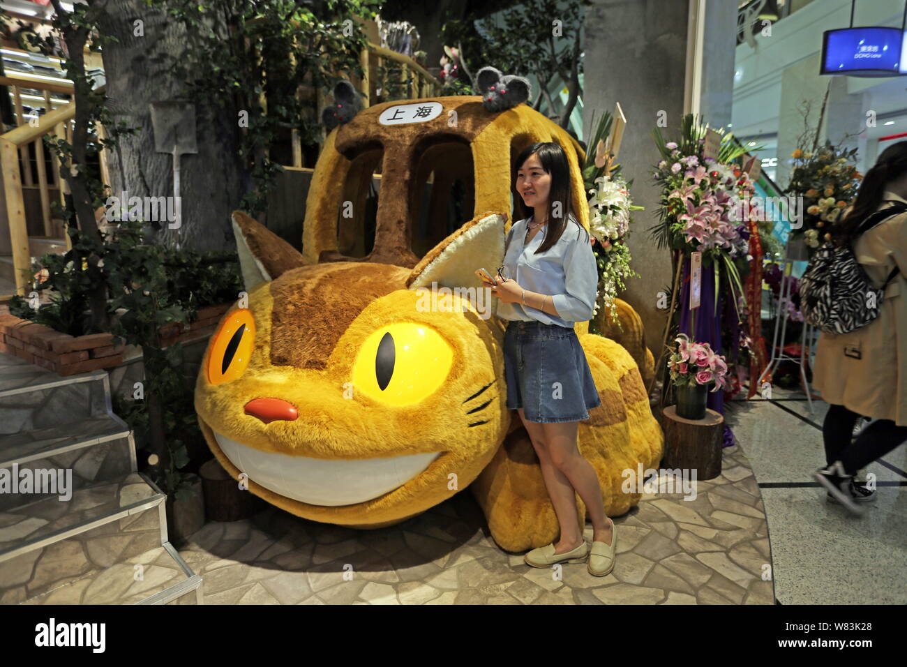A Chinese fan poses with a Catbus of Japanese animated fantasy film 