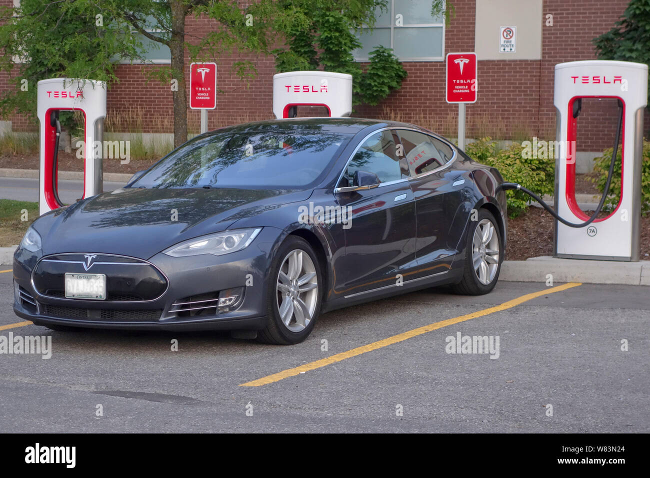 Tesla Model Y plugged in to charging station in Barrie, Ontario Canada Summer 2019 Stock Photo