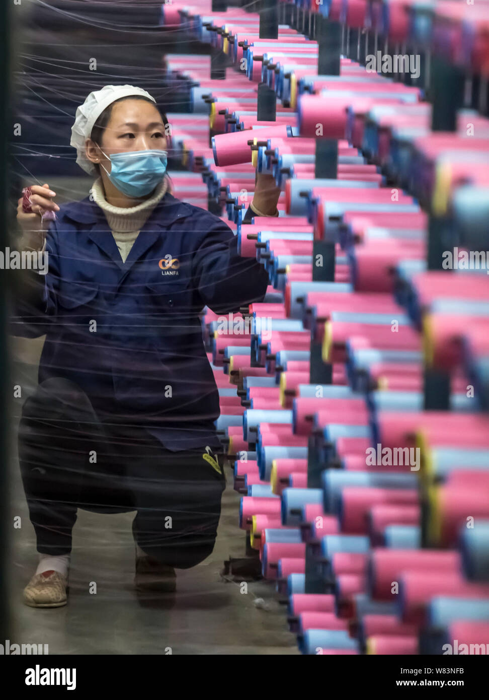 --FILE--A female Chinese worker handles production of yarn at a textile ...