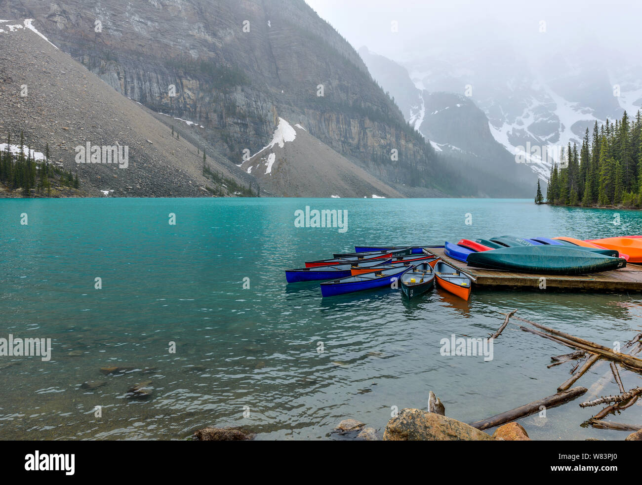 Boat Dock - A snowy and foggy Spring day view of boat dock at Moraine Lake, Banff National Park, Alberta, Canada. Stock Photo