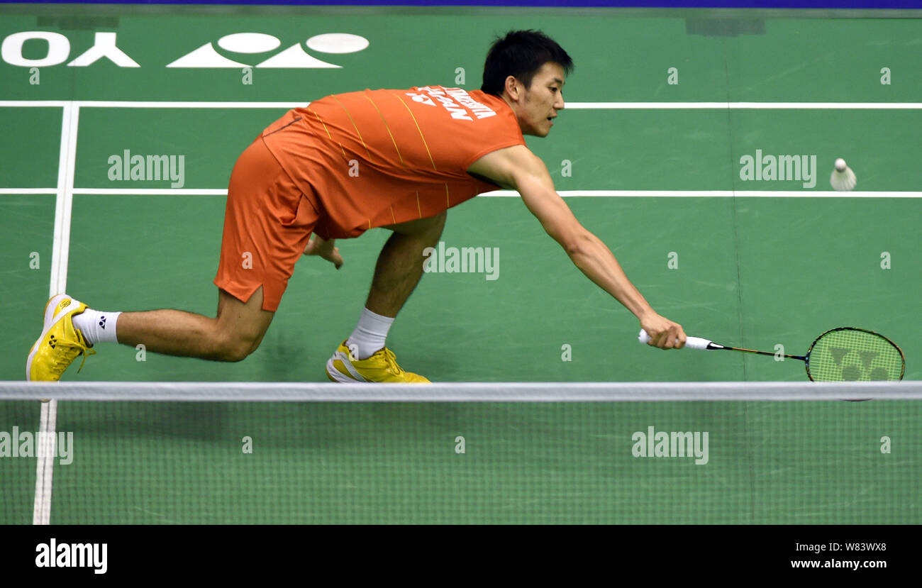 Riichi Takeshita of Japan plays a return shot to Rajiv Ouseph of England in their men's singles