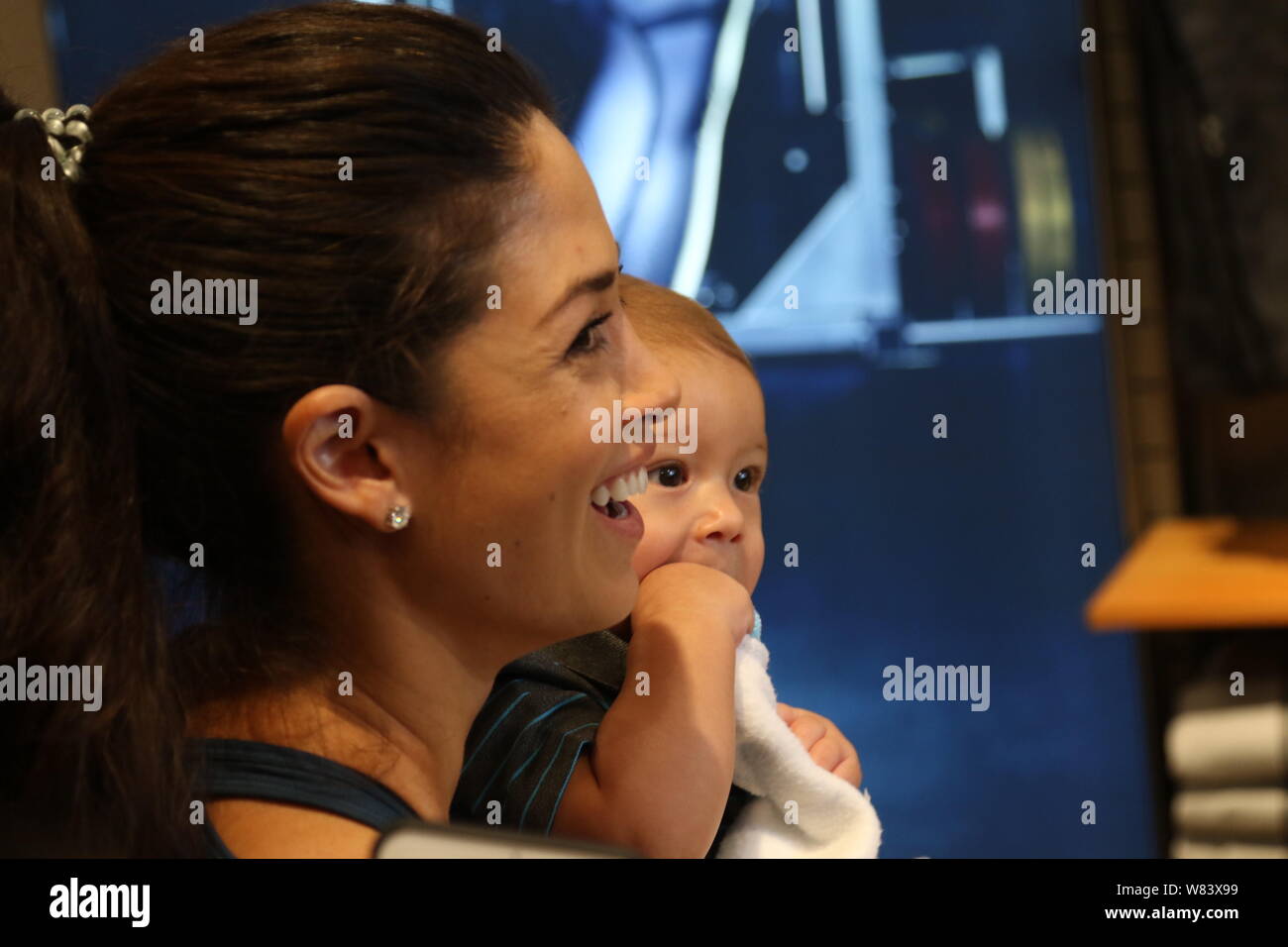 Nicole Johnson, the fiancee of American swimming star Michael Phelps, holds their son Boomer as she looks at Michael Phelps during a fan meeting at th Stock Photo