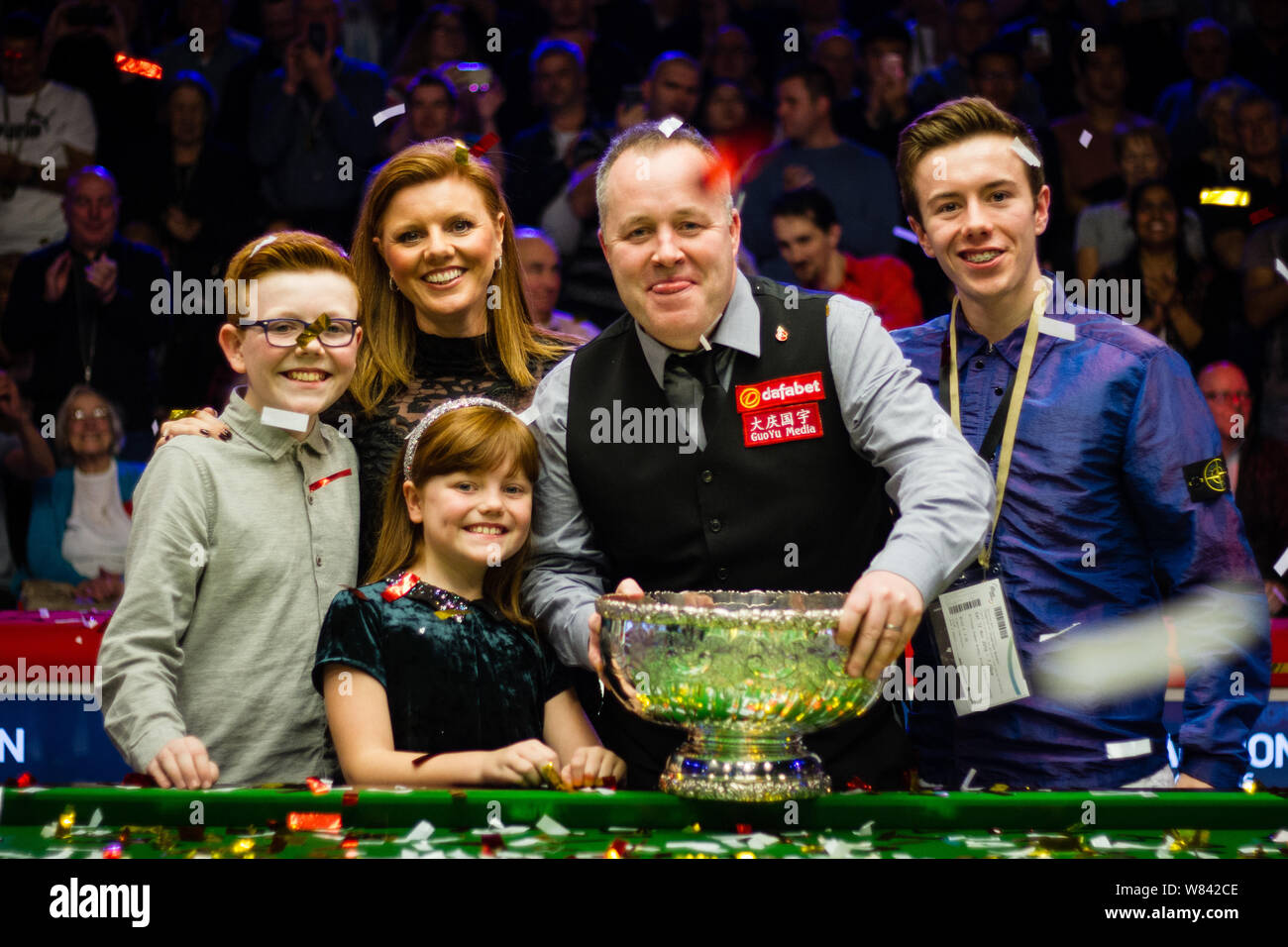 John Higgins of Scotland, second right, poses with his family and champion trophy after defeting Ronnie OSullivan of England in their final match dur Stock Photo