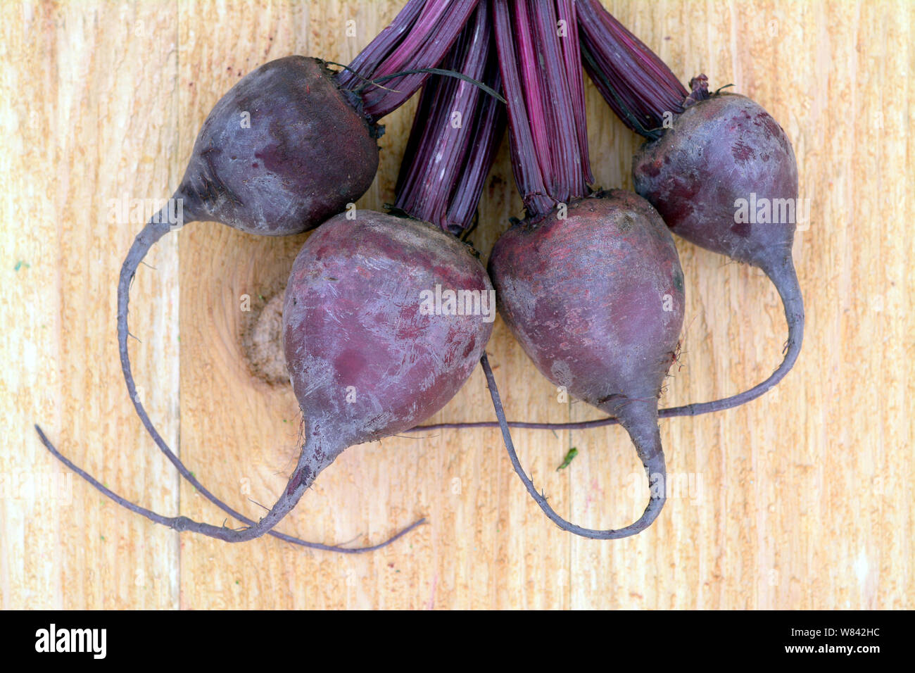 Four beetroots on wooden table Stock Photo