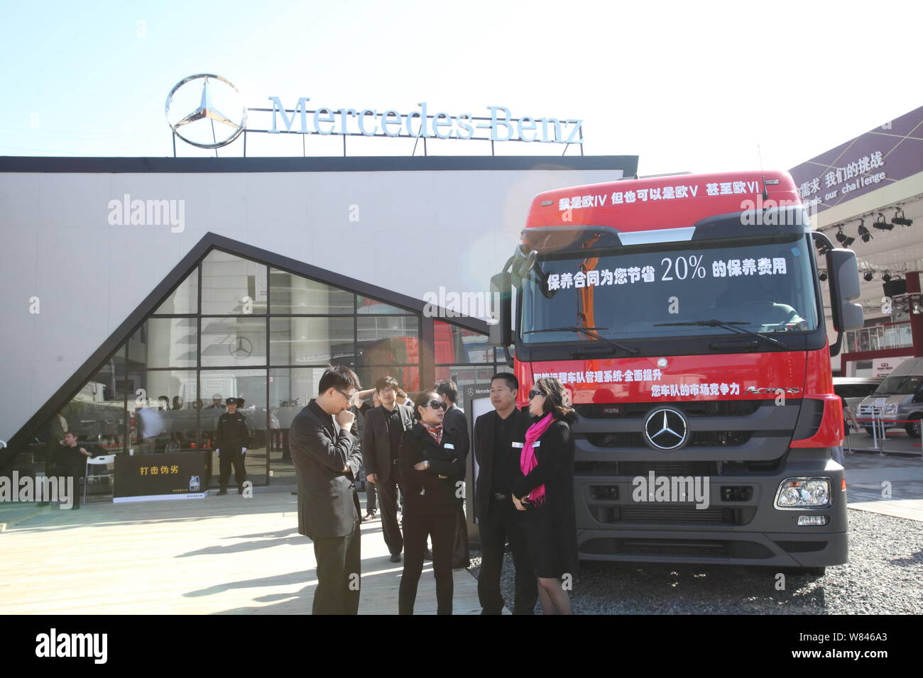 --FILE--People talk next to a Mercedes-Benz Actros heavy truck of Daimler on display during the 12th Beijing International Automotive Exhibition, also Stock Photo