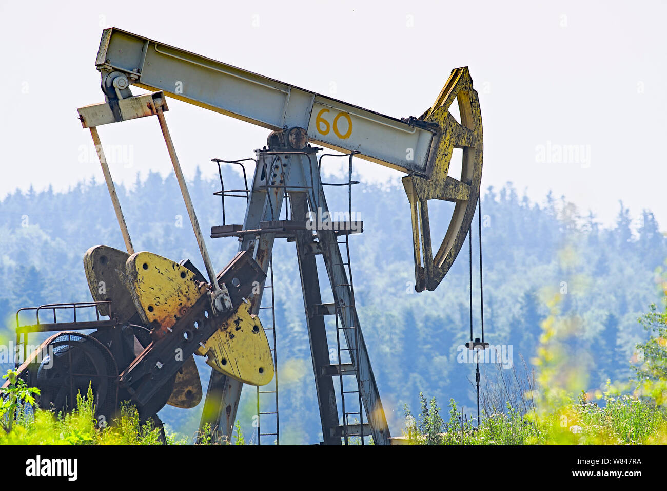 Oil and gas industry. Work of oil pump jack on a oil field. White clouds and blue sky Stock Photo