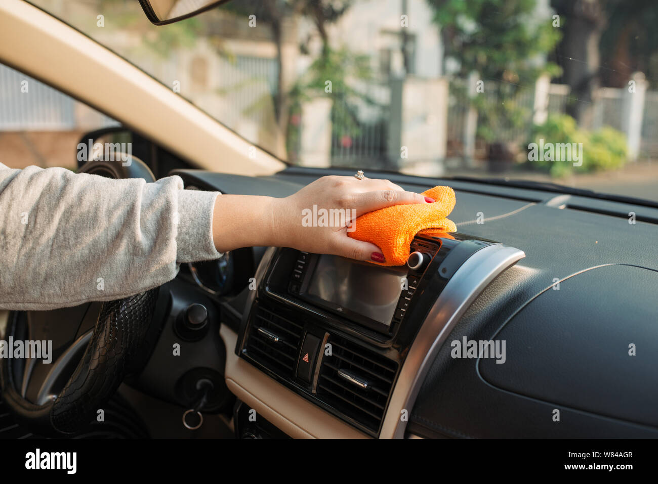 Hand with microfiber cloth cleaning seat, auto detailing and valeting concept, washing car care interior, selective focus Stock Photo