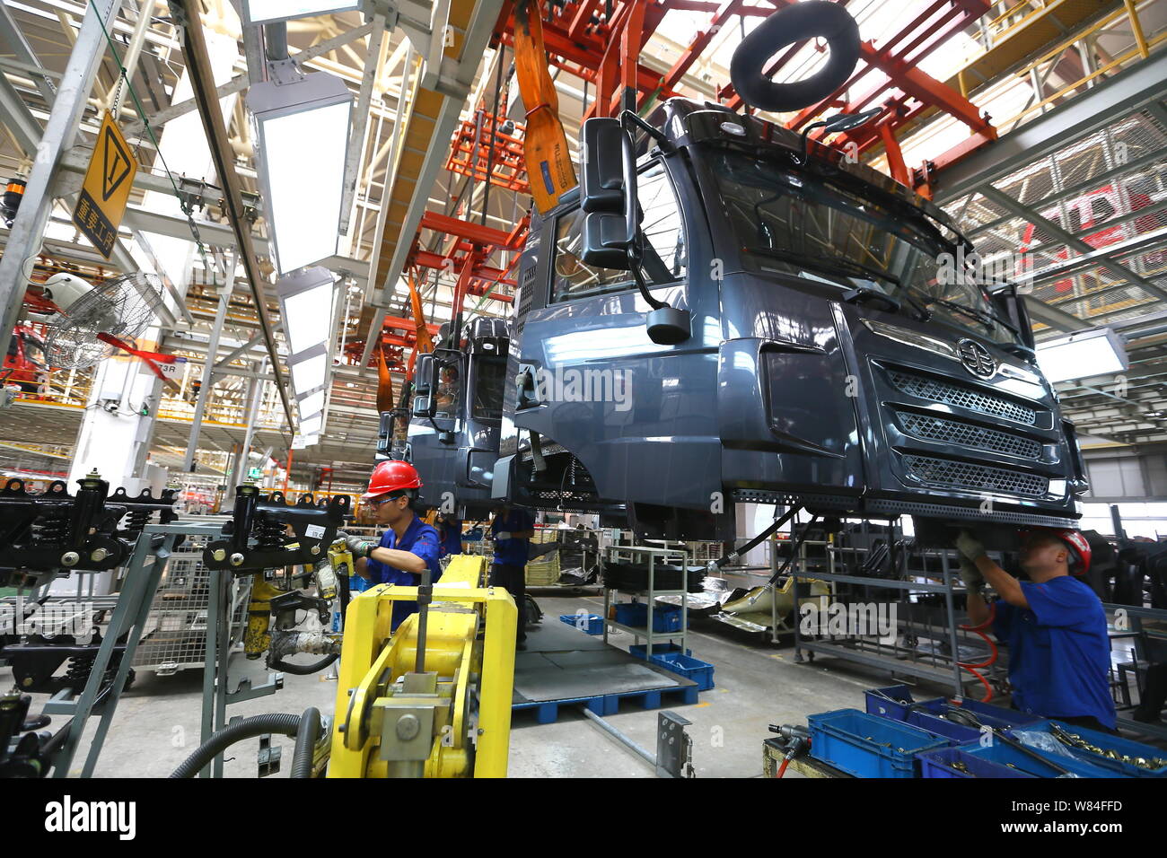 Chinese workers assemble trucks at a plant of FAW in Qingdao city, east China's Shandong province, 29 September 2016.   Activity in China's manufactur Stock Photo