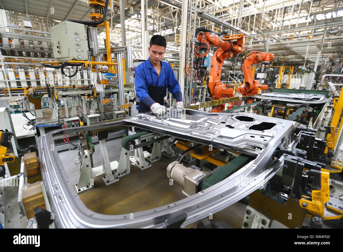 A Chinese worker manufactures doors of rucks at a plant of FAW in Qingdao city, east China's Shandong province, 29 September 2016.   Activity in China Stock Photo