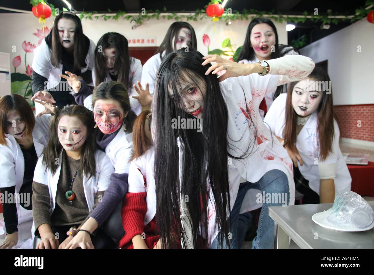 Young women with zombie makeups pose during a gathering to celebrate Halloween at a barbecue restaurant in Binzhou city, east China's Shandong provinc Stock Photo
