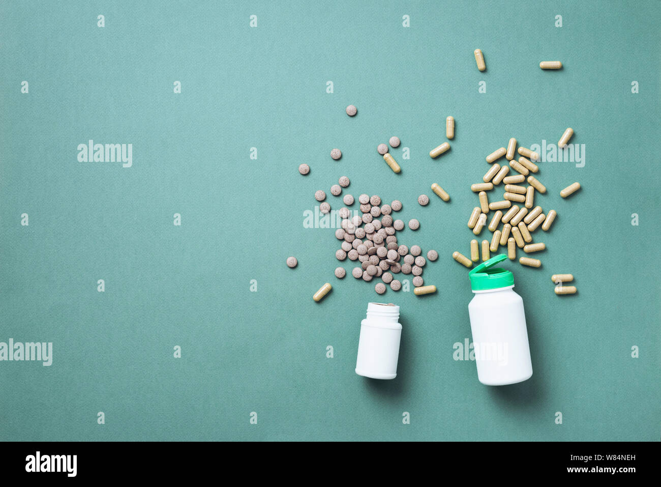 Eucalyptus extract capsules, pills, tabletes over green background with copy space. Prevention and health concept. Alternative medicine. Stock Photo
