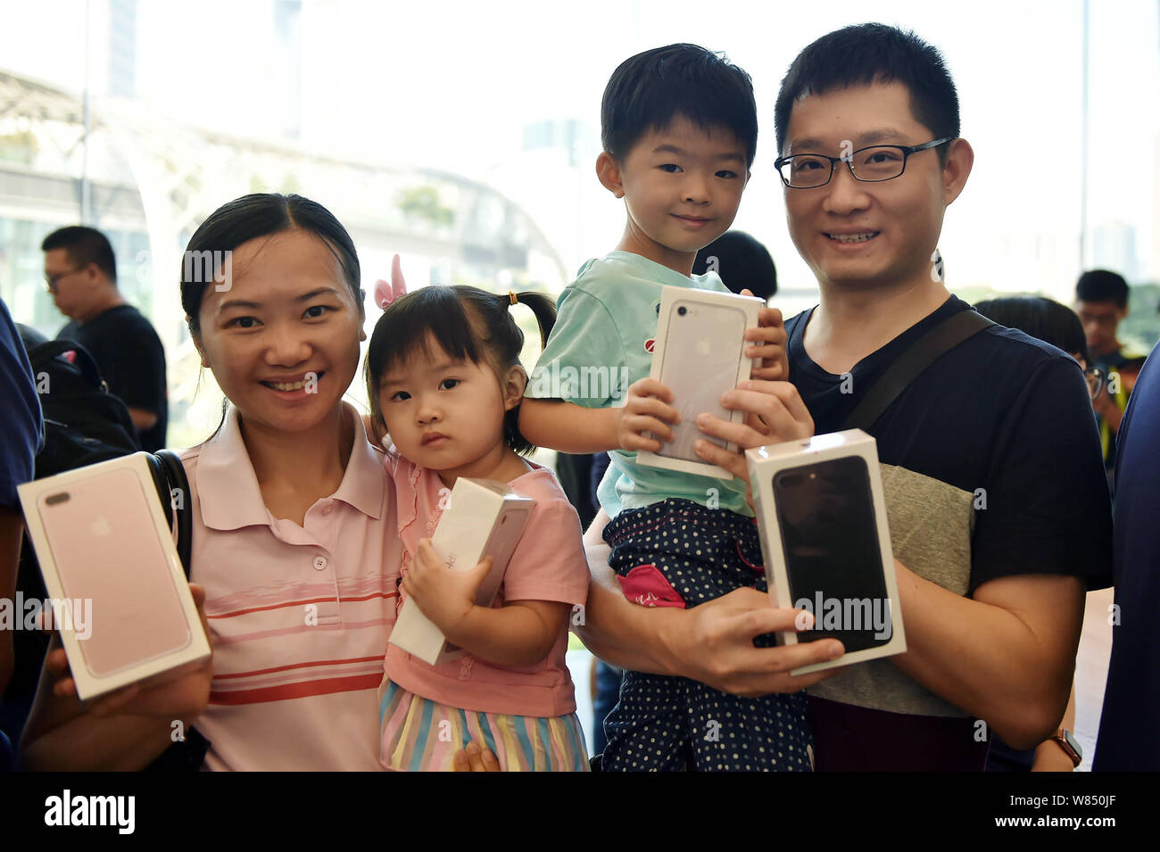 A Chinese family of four shows iPhone 7 and 7 Plus smartphones they bought at an Apple Store in Guangzhou city, south China's Guangdong province, 16 S Stock Photo