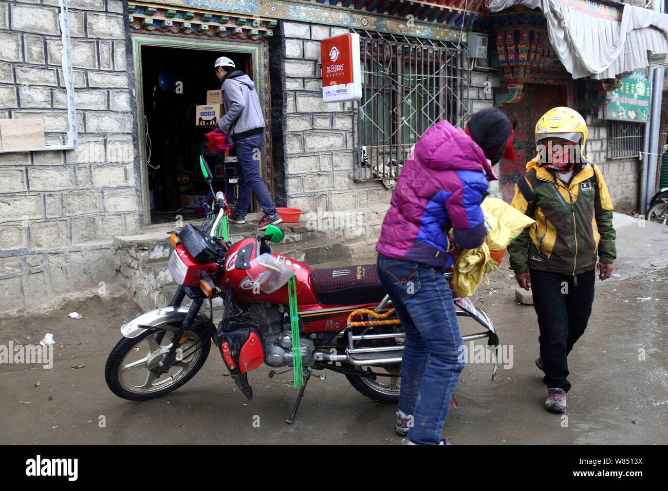 Chinese courier and station chief Yang Tao, left, carries parcels from