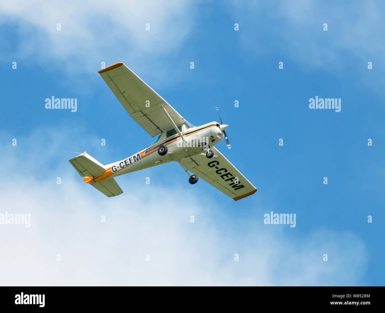 A Cessna 152 in flight and pictured against a blue sky Stock Photo