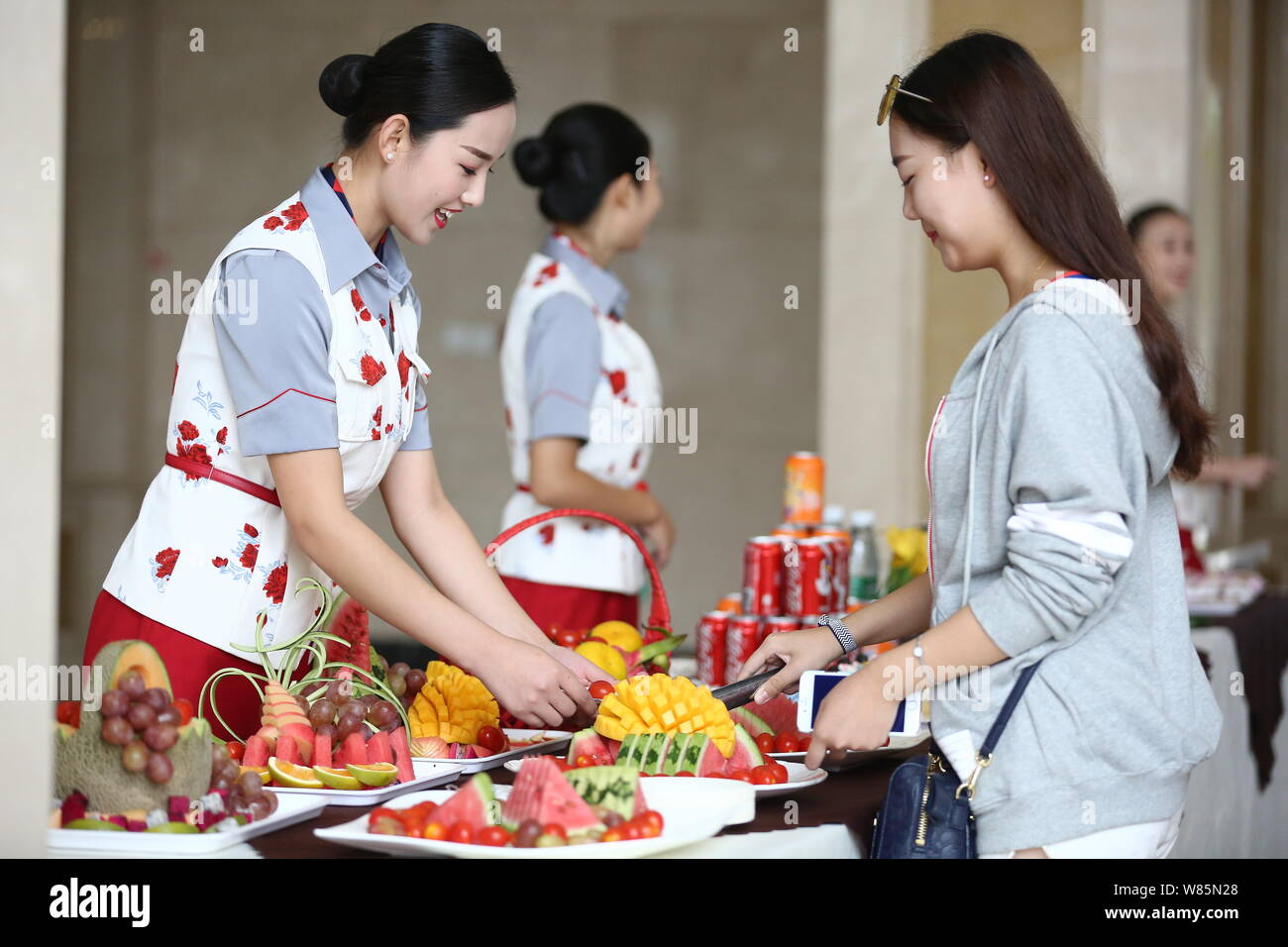 A college student dressed in a uniform of air hostess offers fruits to freshmen at Sichuan Southwest Vocational College of Civil Aviation in Chengdu c Stock Photo