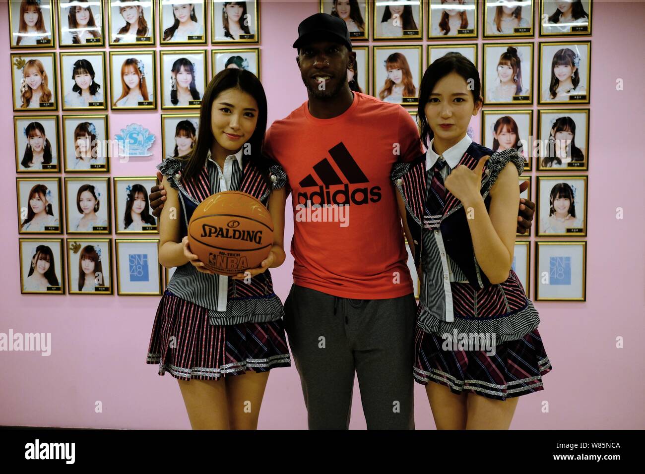 Retired NBA star Chauncey Billups, center, poses with Dai Meng, left, and Wu Zhehan, right, of Chinese girl group SNH48 at their concert in Shanghai, Stock Photo