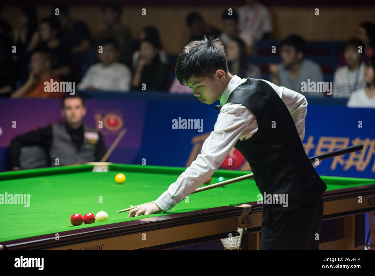 Yuan Sijun of China plays a shot against Mark Selby of England during