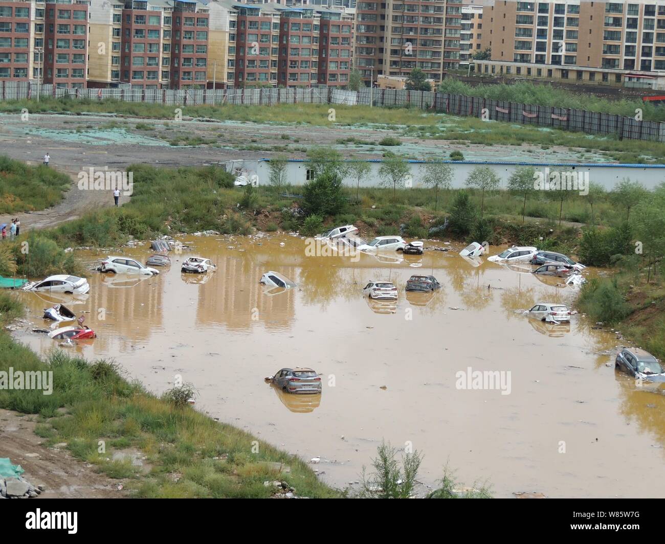 Private cars are submerged in the water after being washed by floods ...