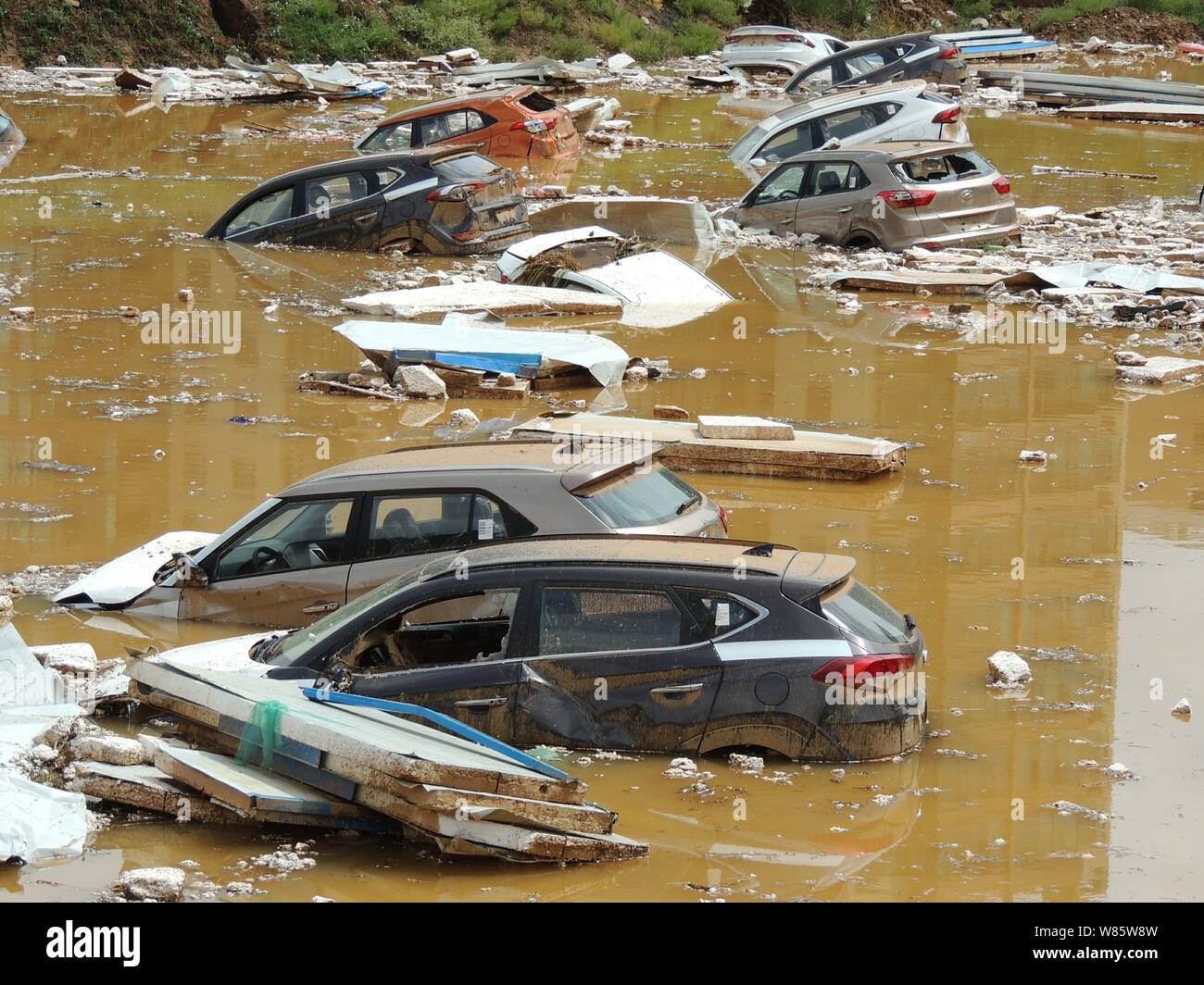 Private cars are submerged in the water after being washed by floods ...