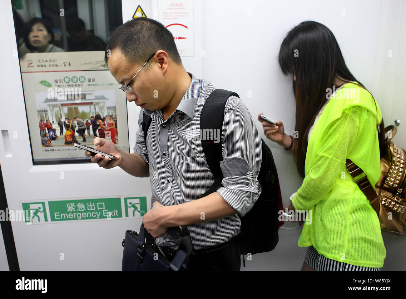 --FILE--Passengers use their smartphones to surf the Internet in a subway train in Hangzhou city, east China's Zhejiang province, China, 21 May 2014. Stock Photo