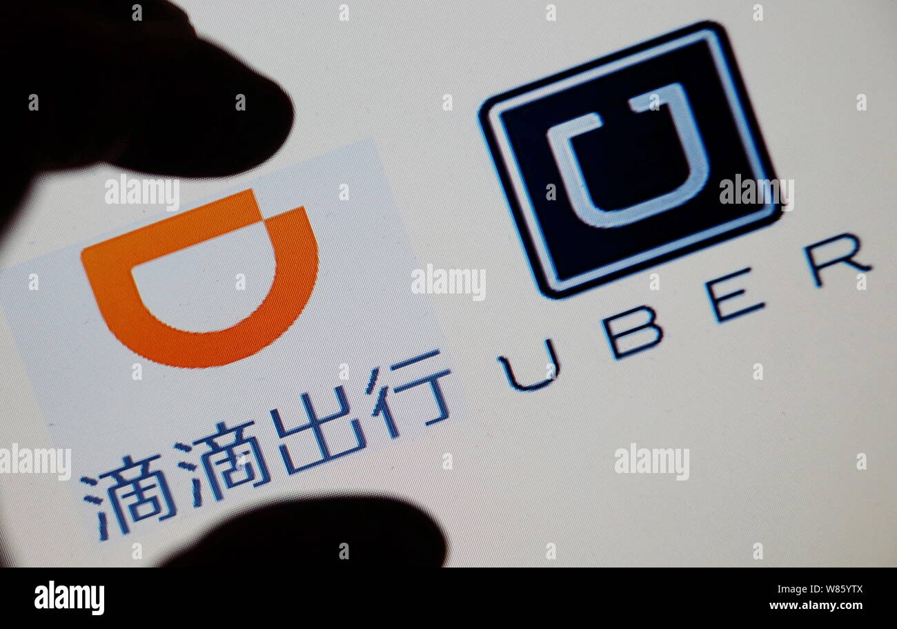 A Chinese resident shows the logos of taxi-hailing apps Didi 