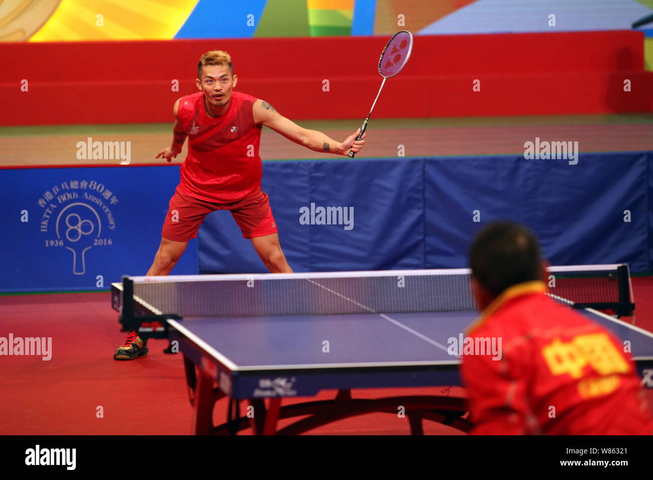 Chinese badminton star Lin Dan, back, competes with Liu Guoliang, coach