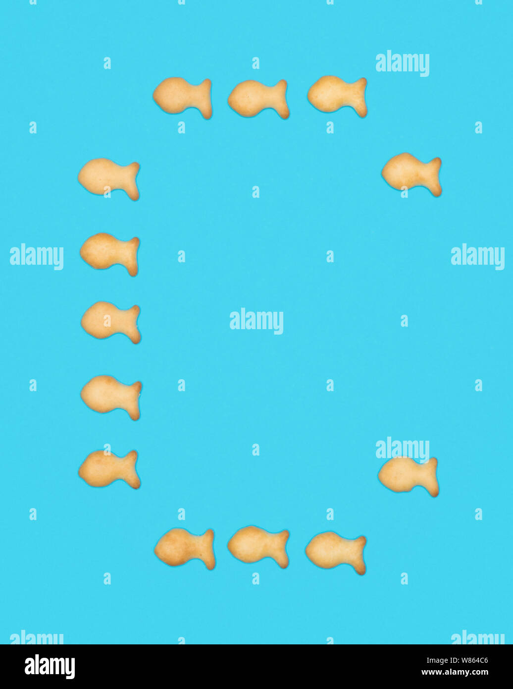 Capital letter C latin alphabet from cookies in the shape of fish on a blue background Stock Photo