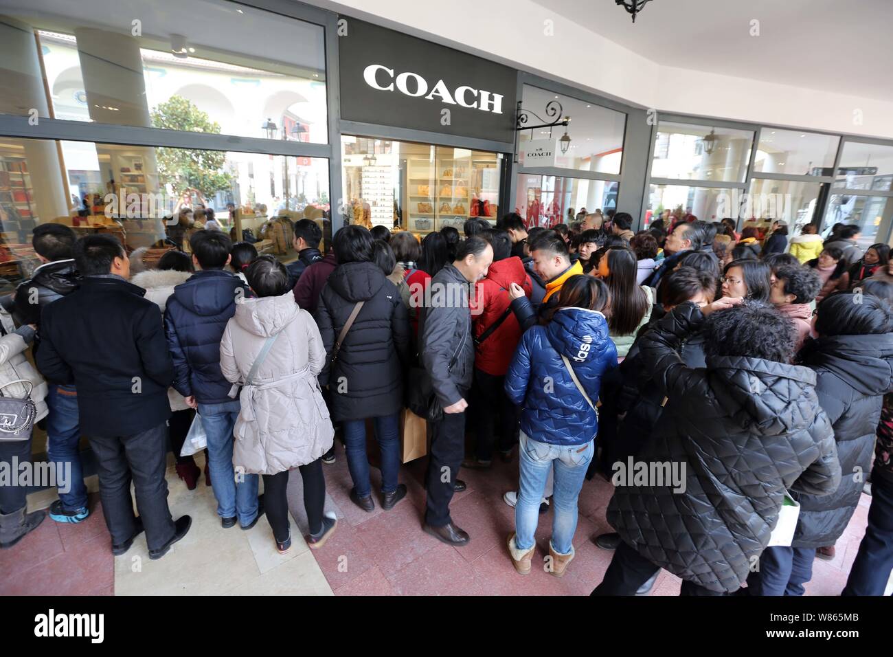 --FILE--Chinese shoppers queue up to enter a store of American fashion house Coach at the Florentia Village outlet mall in Pudong, Shanghai, China, 22 Stock Photo