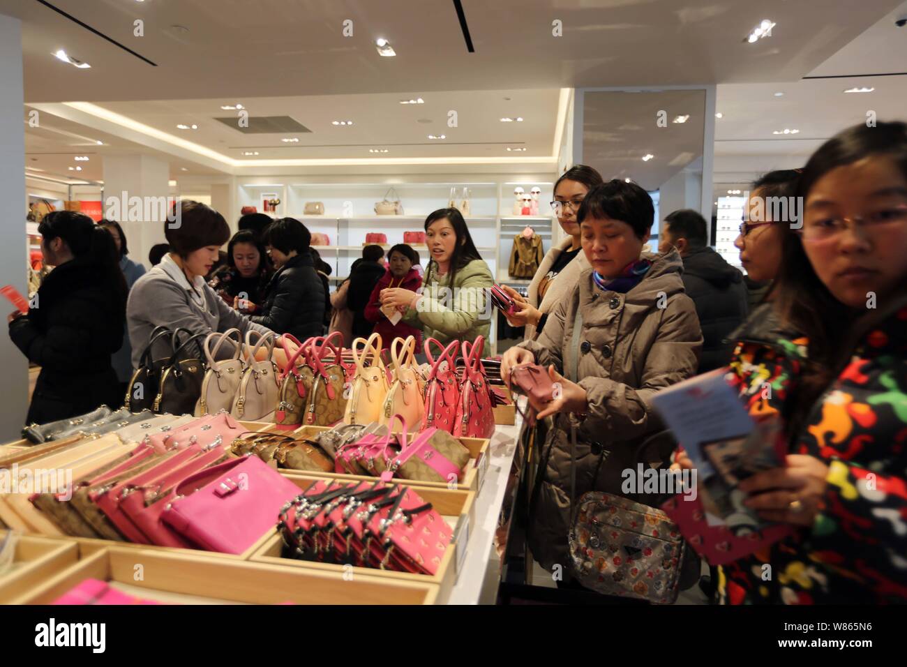 --FILE--Chinese shoppers buy bags and purses in a store of American fashion house Coach at the Florentia Village outlet mall in Pudong, Shanghai, Chin Stock Photo