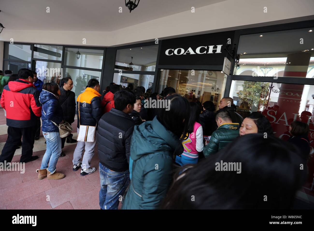 --FILE--Chinese shoppers queue up to enter a store of American fashion house Coach at the Florentia Village outlet mall in Pudong, Shanghai, China, 22 Stock Photo