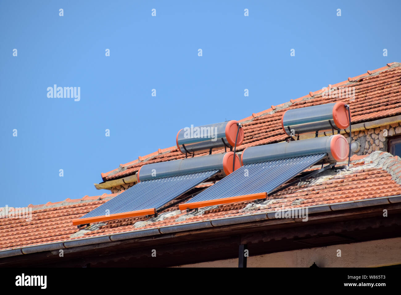 solar panels and barrels for heating water on the roof of the house ...