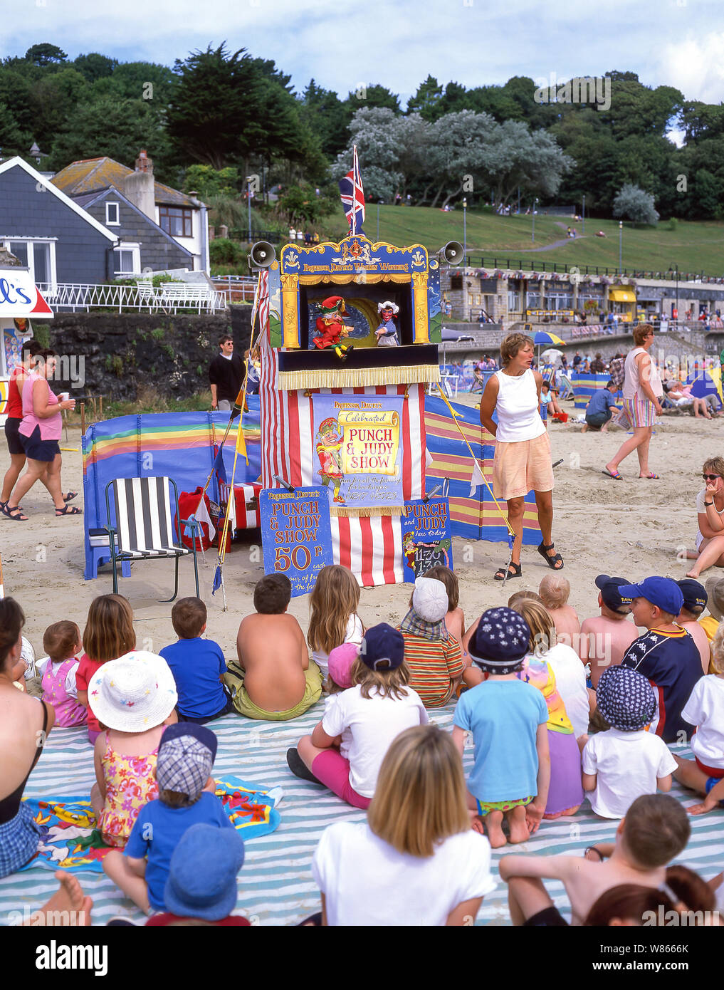 Children watching traditional 'Punch and Judy' puppet show on beach, Lyme Regis, Dorset, England, United Kingdom Stock Photo