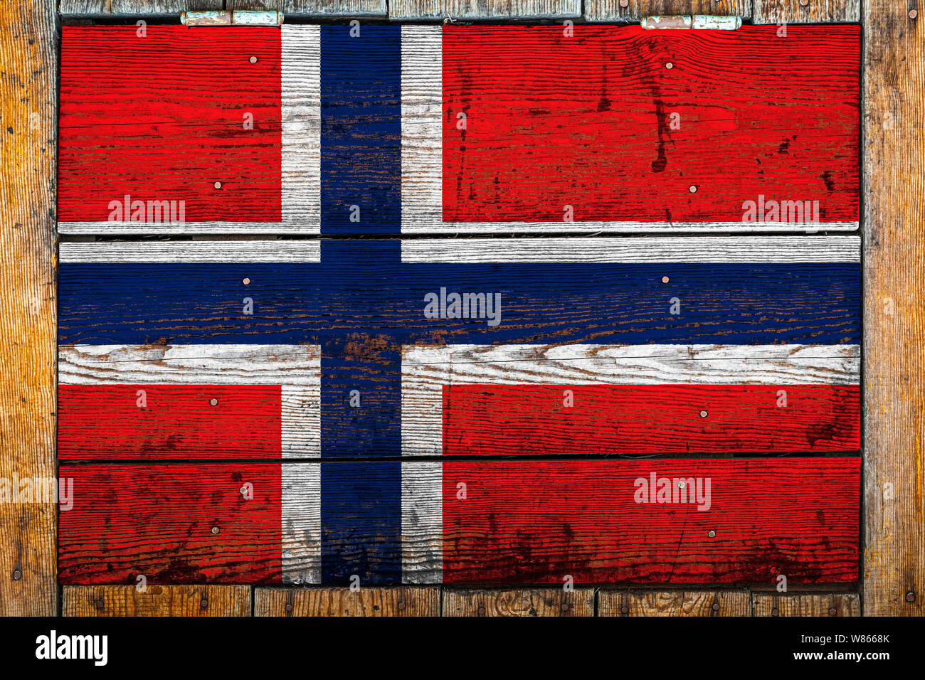 National flag of Norway on a wooden wall background.The concept of national pride and symbol of the country.Flag painted on a wooden fence with metal Stock Photo