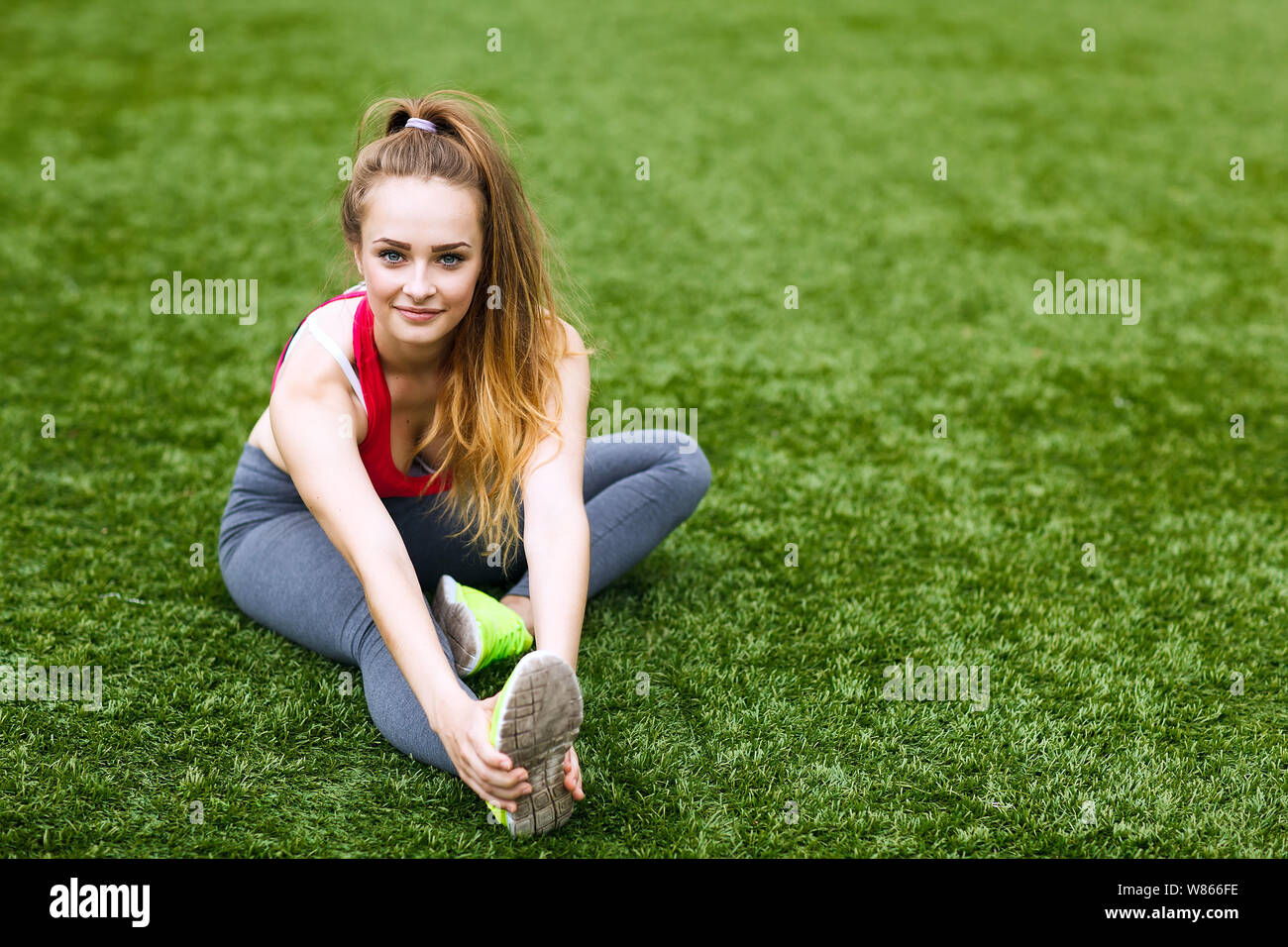 Happy young woman sitting outdoors in yoga position Stock Photo - Alamy
