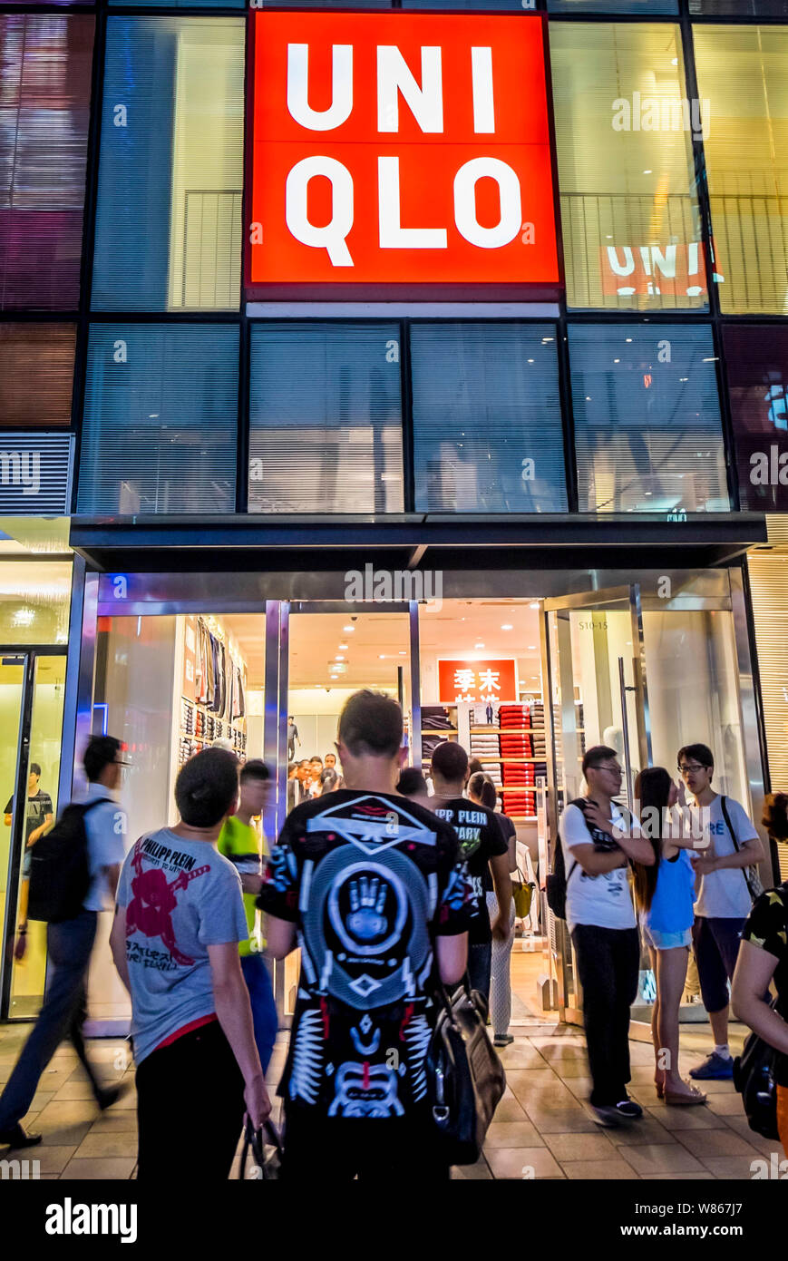 FILE--Pedestrians walk past a Uniqlo store in Beijing, China, 15 July 2015.  Uniqlo, a Japan-based clothing company, reported a decline in operatin  Stock Photo - Alamy