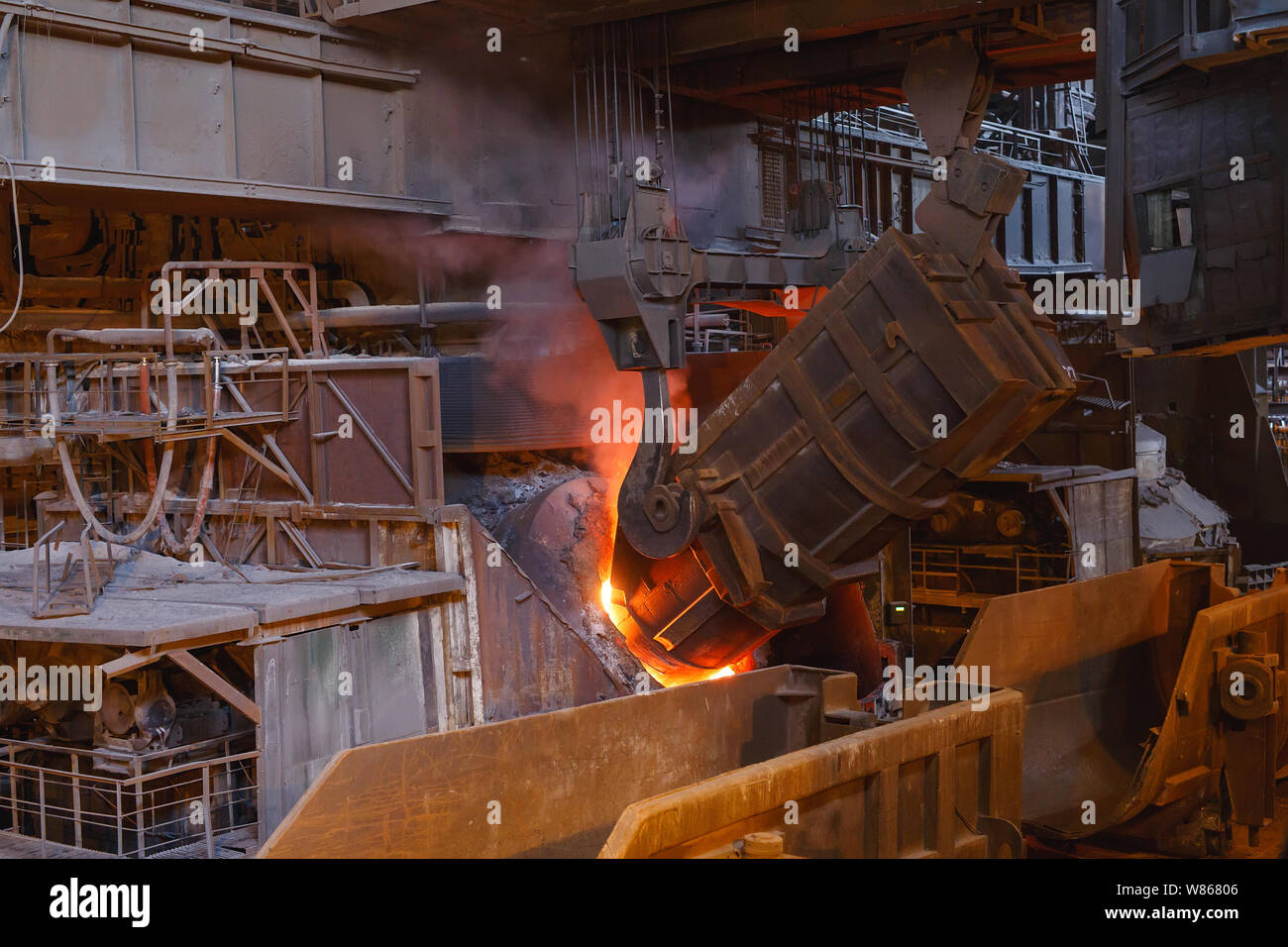 smelting of the metal in the foundry, Factory worker takes a sample for metal. Stock Photo
