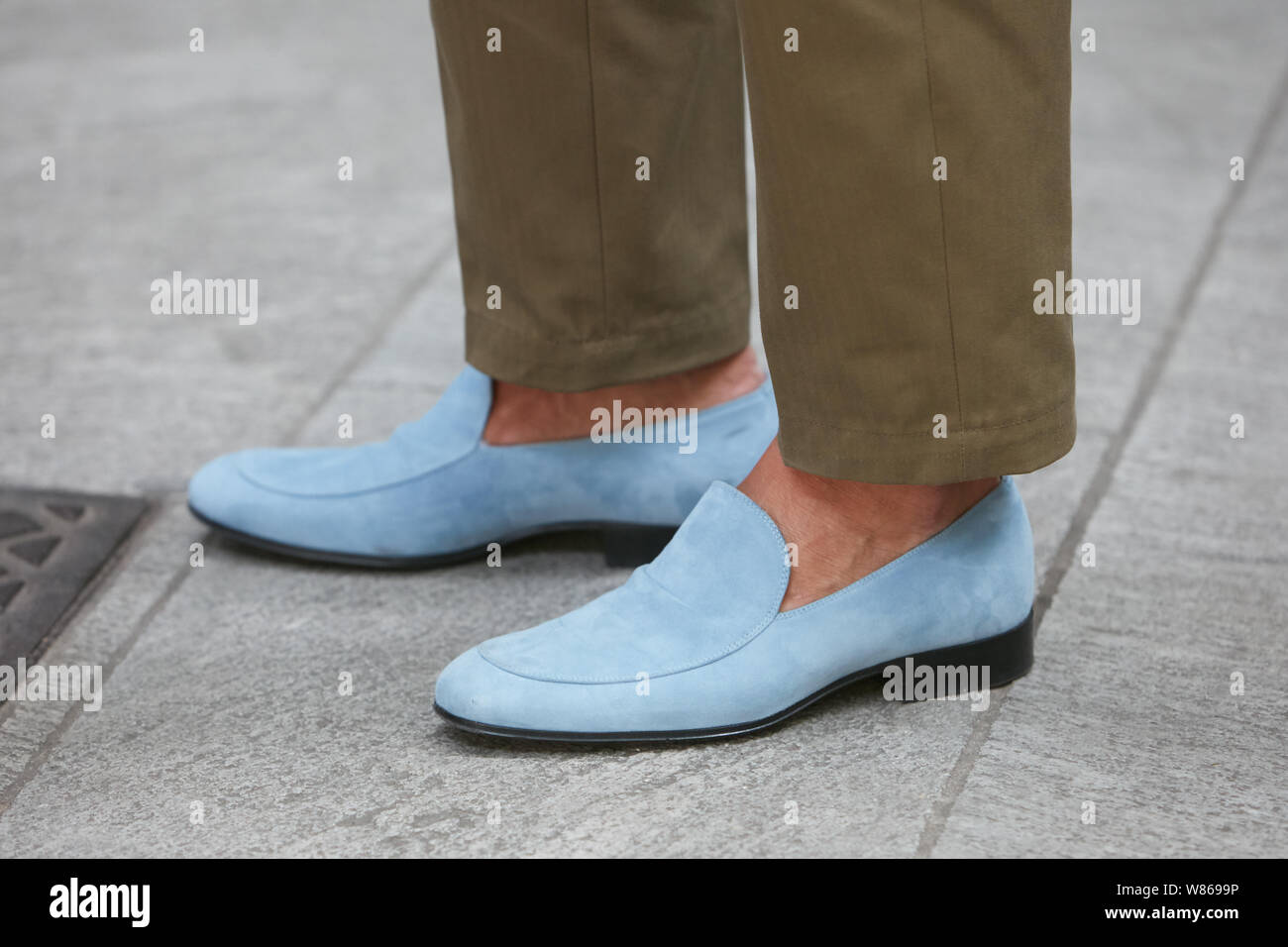 MILAN, ITALY - JUNE 15, 2019: Man with pale blue suede shoes and brown trousers before Emporio Armani fashion show, Milan Fashion Week street style Stock Photo